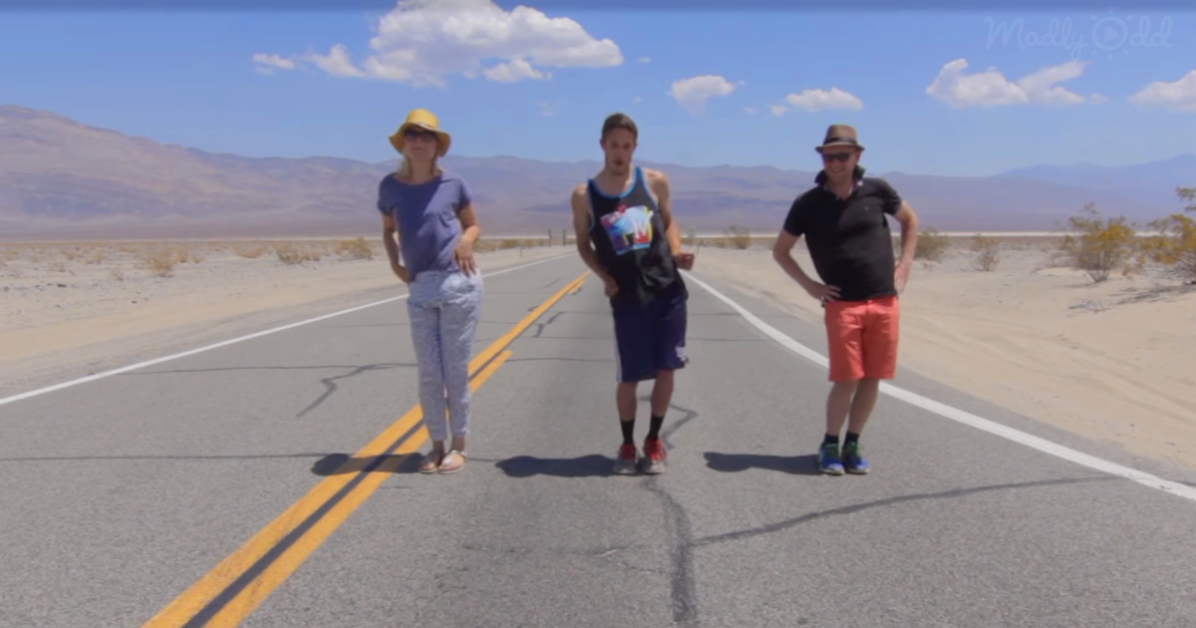 Matt Bray and 2 friends dancing on a road in the middle of a desert