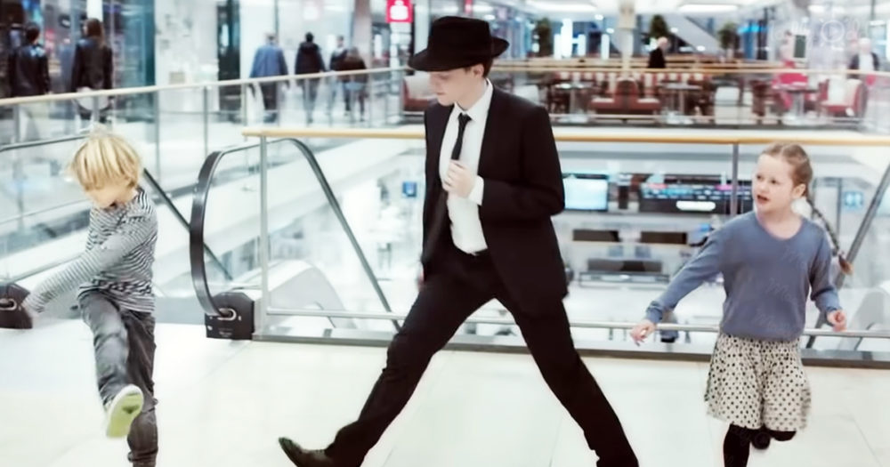 Energetic guy dances inside a shopping mall