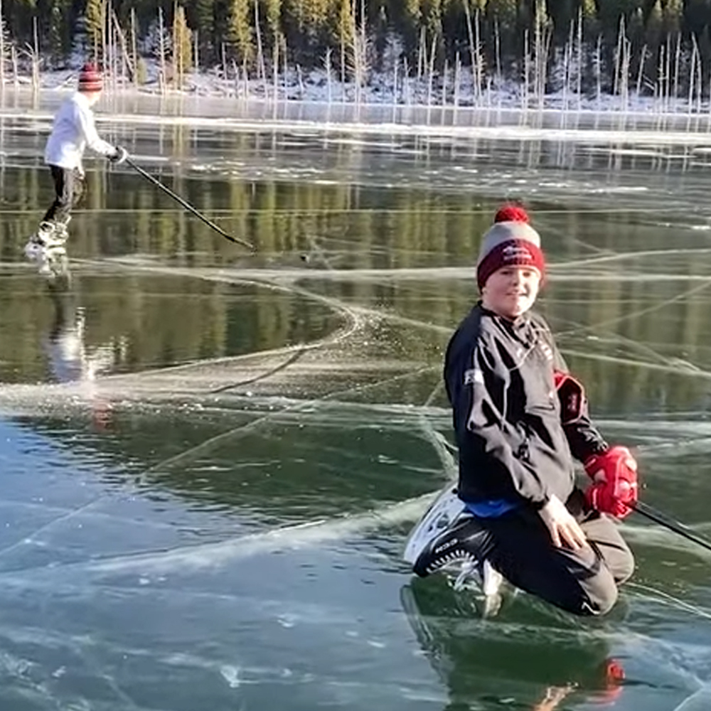 Kids practicing hockey on a frozen Lake