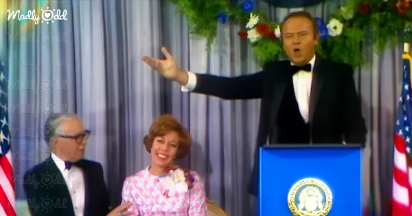 Harvey Korman in front of Presidential podium, Carol Burnett sitting by his side.