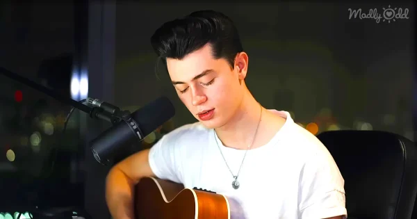 Ellion James Reay playing the guitar, white t-shirt, looking HAF.