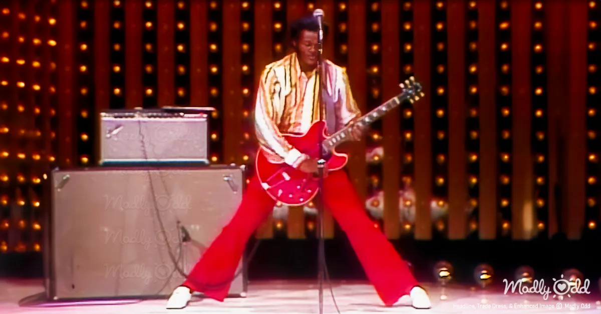 Chuck Berry wearing red bellbottoms and white shirt. Iconic pose with his guitar.